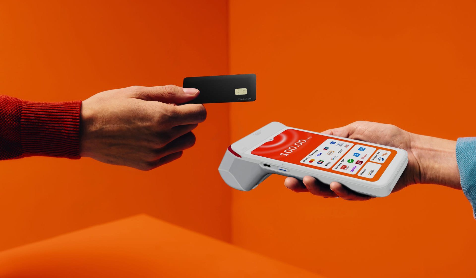 A customer tapping a black STARPAY card on the orange STARPAY smart terminal